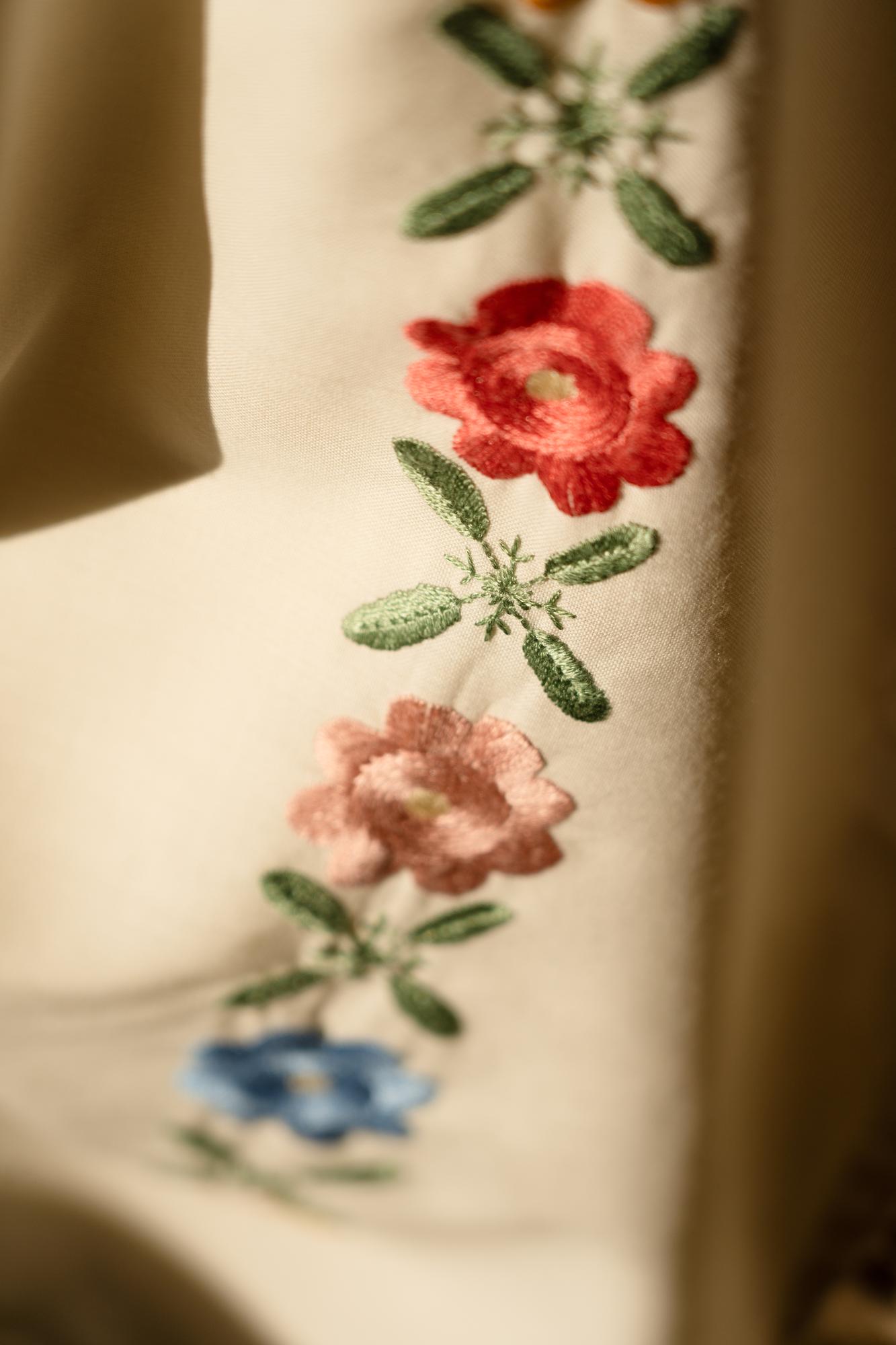 Close-up of floral embroidered patch on linen